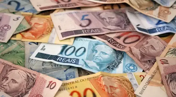 Stosy banknotów w różnych nominałach, w tym 100, 10 i 5 reali. To waluta w Brazylii.