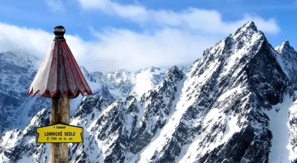 Słowacja góry: szczyt Łomnickie Sedlo (2190 m n.p.m.) w Tatrach Wysokich, pokryty śniegiem, z charakterystycznym drewnianym słupkiem i tabliczką.