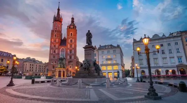 Zachód słońca nad Rynkiem Głównym. Bazylika Mariacka i pomnik Mickiewicza w pięknym, historycznym otoczeniu. Stare miasto w Krakowie zachwyca o każdej porze.