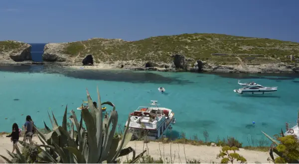Malta wycieczki: turkusowa woda, łodzie i skaliste wybrzeże. Idealne miejsce na wakacje.