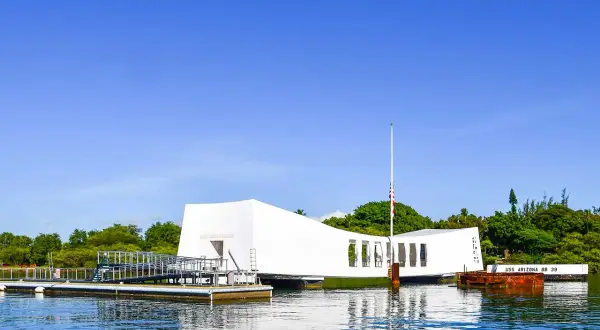 Pomnik USS Arizona w Pearl Harbor, biała konstrukcja nad wodą, upamiętnia tragiczne wydarzenia.