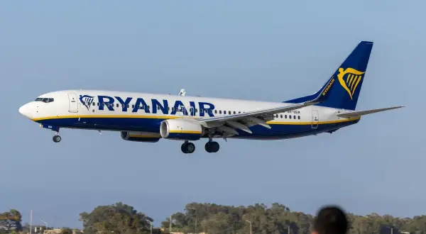 Samolot Ryanair zbliża się do lądowania. Widok z lotniska, gdzie czeka pasażer na odprawę.