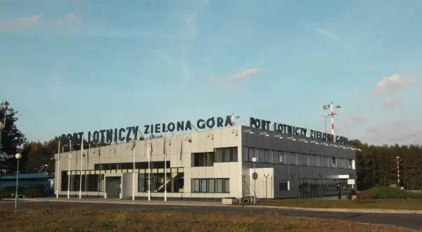 Port Lotniczy Zielona Góra Babimost. Budynek terminala lotniska z napisem na dachu.
