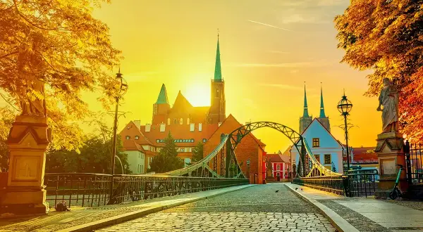 Zachód słońca nad Ostrowem Tumskim we Wrocławiu, idealny na city break z Wrocławia. Most Tumski i katedra w złotym blasku.