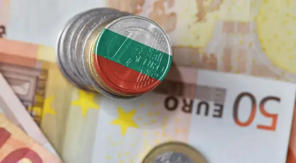 Monety z flagą Bułgarii leżą na banknotach euro. Waluta Bułgarii, lew, obok euro.