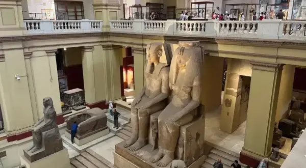 Wielkie posągi faraonów w nowym muzeum w Kairze. Zwiedzający podziwiają starożytne artefakty.