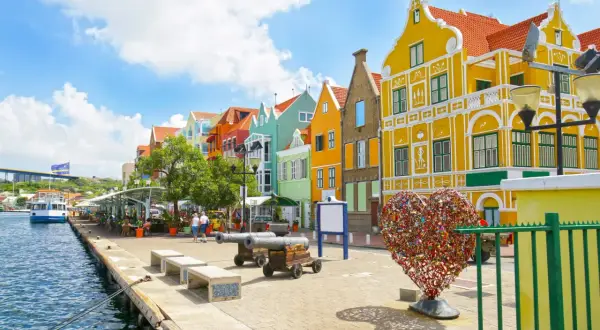 Kolorowe kamienice nad wodą, armaty i serce z kłódek – idealne miejsce na curacao wakacje.