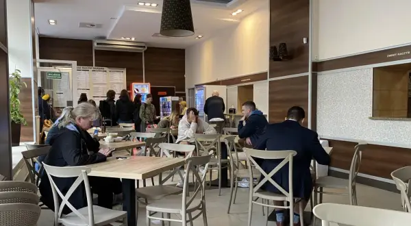 Ludzie jedzą w barze mlecznym, szukając dobrego jedzenia w Warszawie.