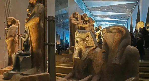 Wielkie posągi faraonów i sfinksów w nowoczesnym wnętrzu muzeum egipskiego.