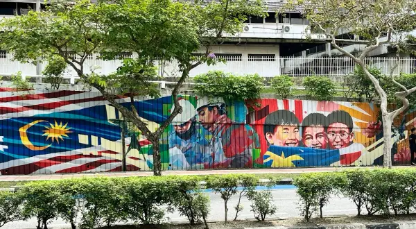 Kolorowy mural z flagą Malezji i uśmiechniętymi dziećmi. Wiza do Malezji może być potrzebna, ale sztuka jest zawsze mile widziana.