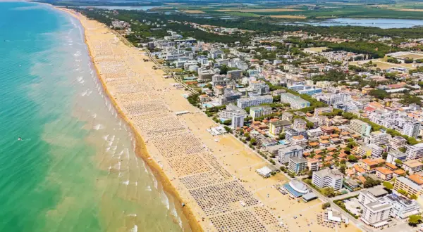 Słoneczna bibione plaża tętni życiem. Tysiące leżaków i parasoli tworzą barwny dywan, a turkusowe morze zaprasza do kąpieli.