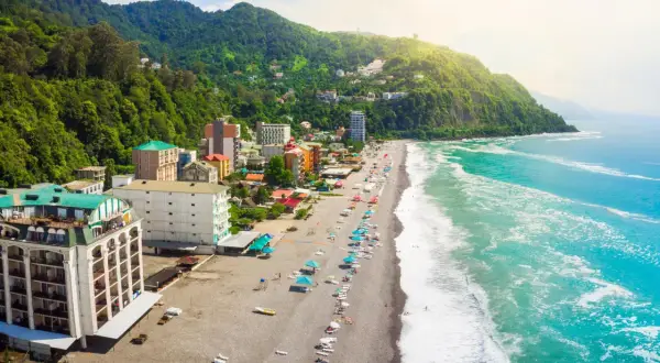 Widok z lotu ptaka na wybrzeże Gruzji. Plaże, hotele i zielone wzgórza nad turkusowym morzem.