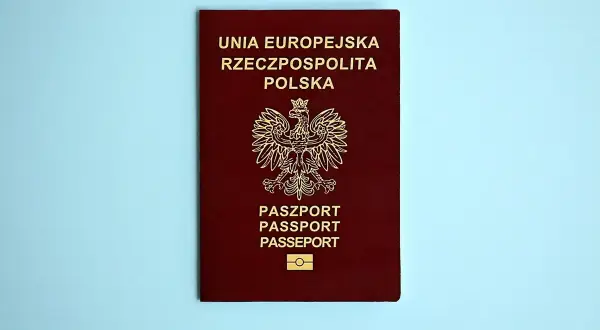 Ciemnoczerwony paszport Rzeczypospolitej Polskiej z godłem i napisem "PASZPORT". Dowiedz się, jak wyrobić paszport.