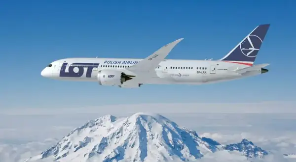 Samolot LOT Polish Airlines leci nad ośnieżonymi górami.