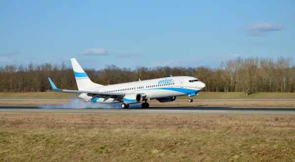 Samolot Enter Air ląduje, wzbijając dym. Ciekawe opinie forum o Enter Air.