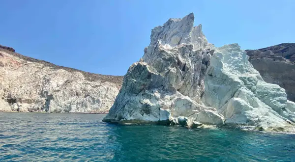 Skaliste wybrzeże Santorini, z turkusową wodą i białymi klifami, zaprasza do odkrywania ukrytych plaż.