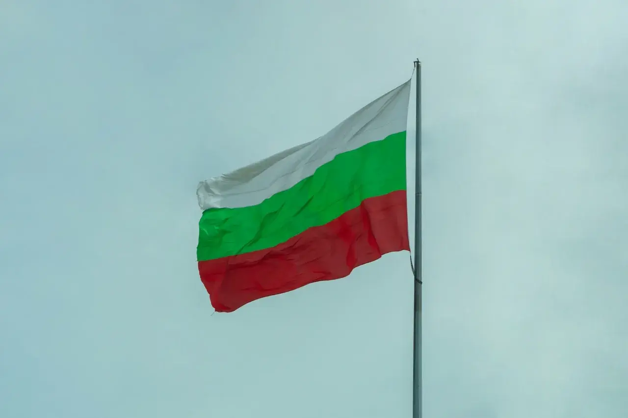 Bułgarska flaga powiewa na tle nieba. Zastanawiasz się nad cenami w Bułgarii?