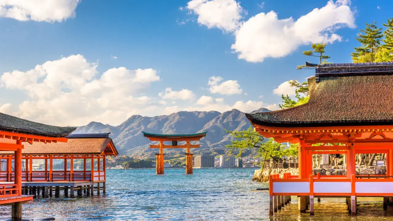 Japonia wycieczka Itaka: widok na słynną bramę torii w morzu i tradycyjne budynki świątynne na wodzie.