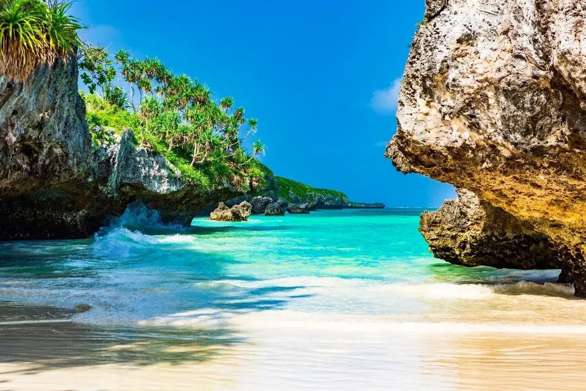Rajska plaża na Zanzibarze, z turkusową wodą i skalistymi klifami porośniętymi zielenią. Idealne miejsce, by zobaczyć, co Zanzibar ma do zaoferowania.