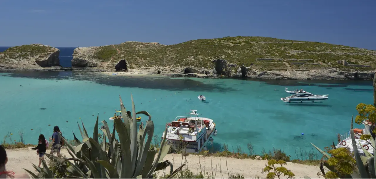 Malta wycieczki: turkusowa woda, łodzie i skaliste wybrzeże. Idealne miejsce na wakacje.