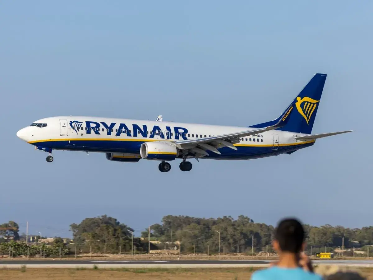 Samolot Ryanair zbliża się do lądowania. Widok z lotniska, gdzie czeka pasażer na odprawę.