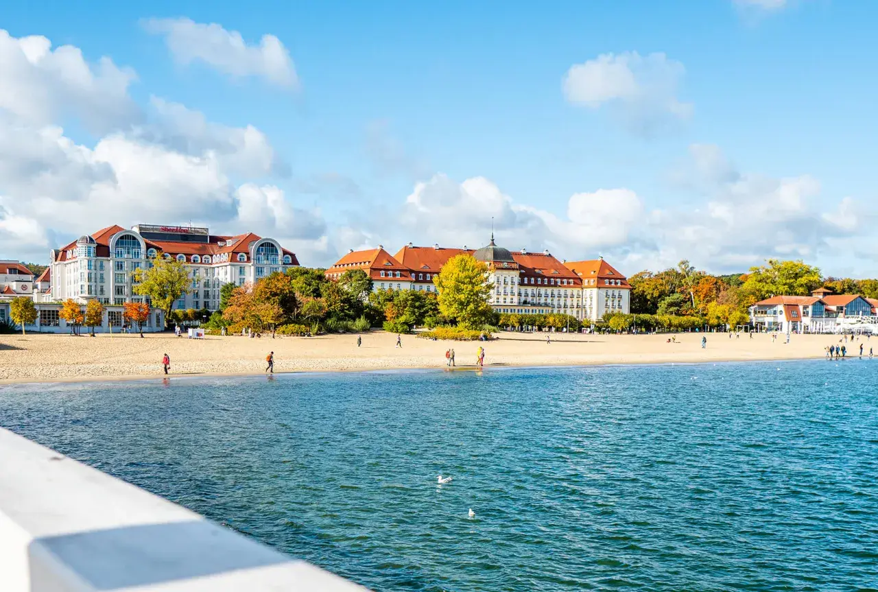 Widok na plażę i morze z hotelami w tle, jesienią.