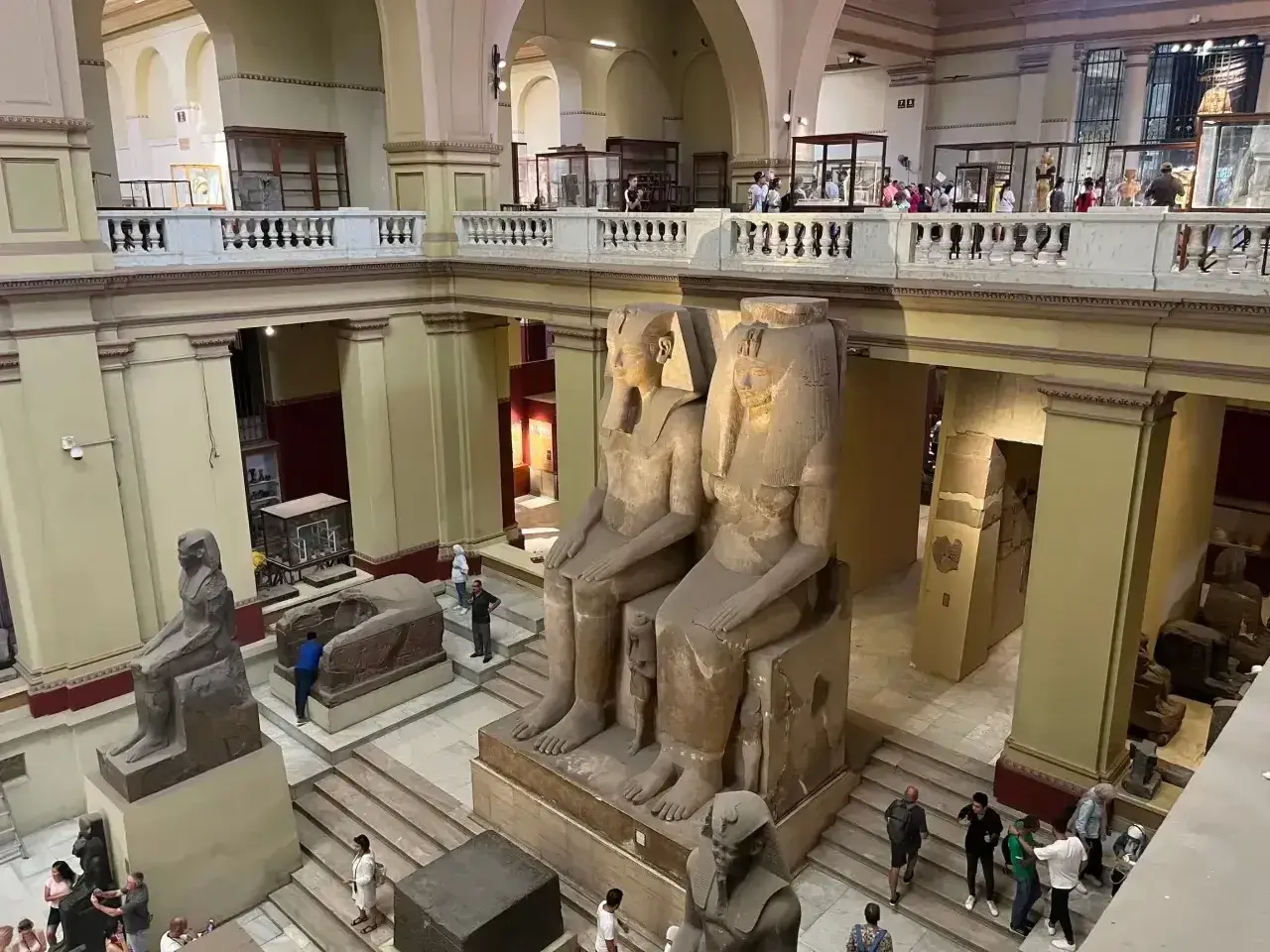 Wielkie posągi faraonów w nowym muzeum w Kairze. Zwiedzający podziwiają starożytne artefakty.