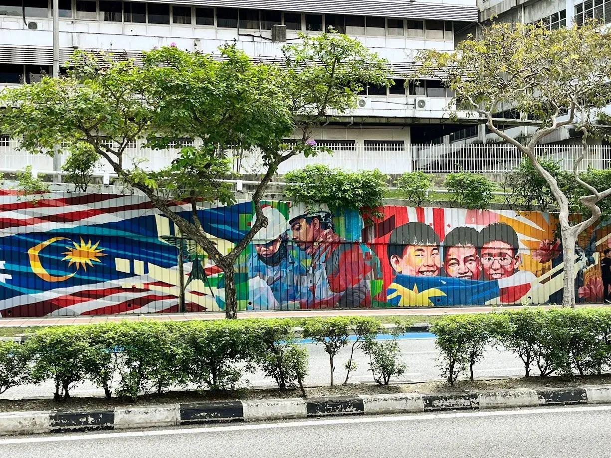 Kolorowy mural z flagą Malezji i uśmiechniętymi dziećmi. Wiza do Malezji może być potrzebna, ale sztuka jest zawsze mile widziana.
