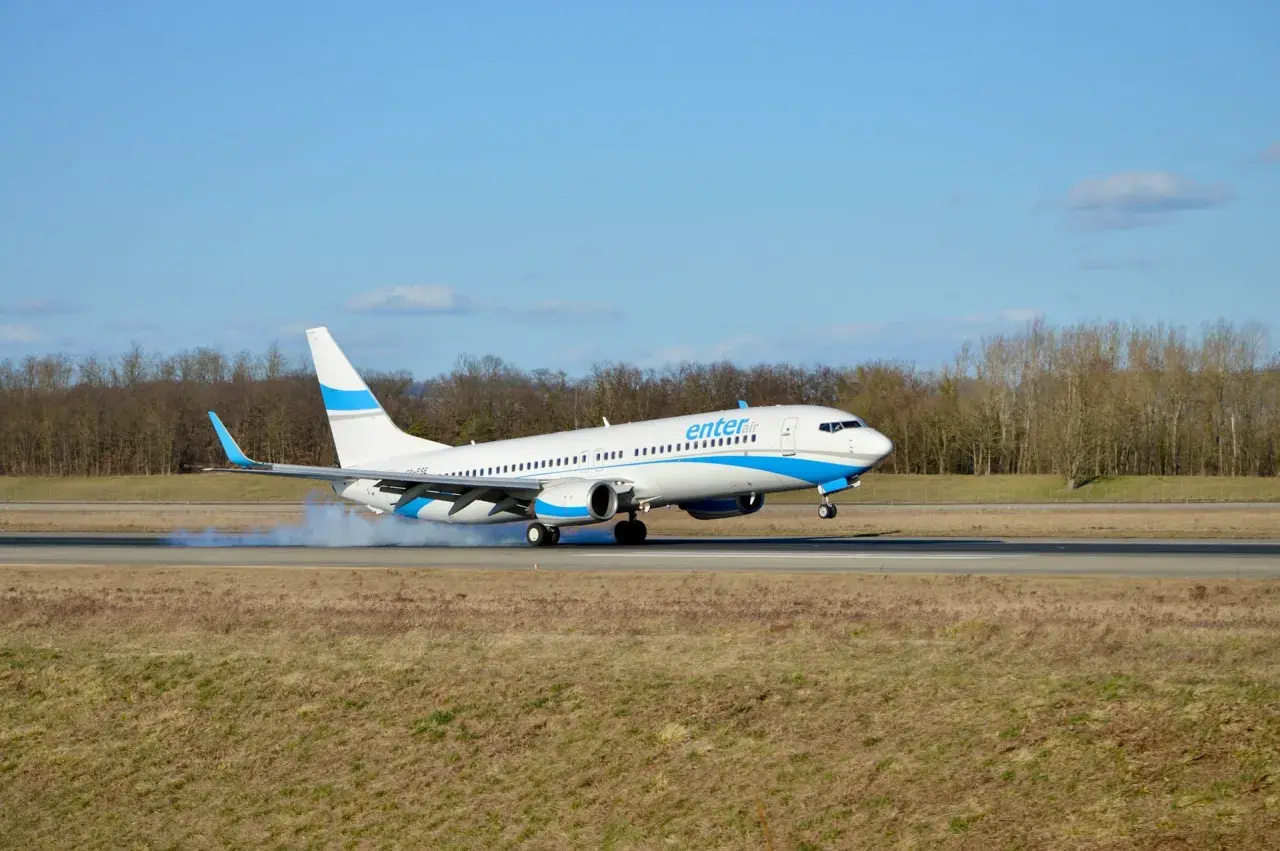 Samolot Enter Air ląduje, wzbijając dym. Ciekawe opinie forum o Enter Air.