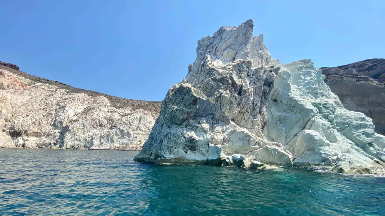 Skaliste wybrzeże Santorini, z turkusową wodą i białymi klifami, zaprasza do odkrywania ukrytych plaż.