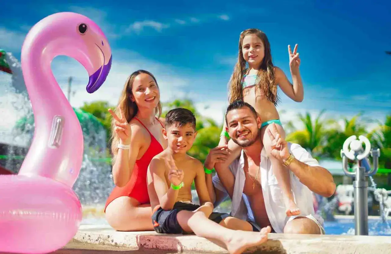 Rodzina cieszy się wakacjami all inclusive Polska, z dmuchanym flamingiem i wodnym placem zabaw w tle.