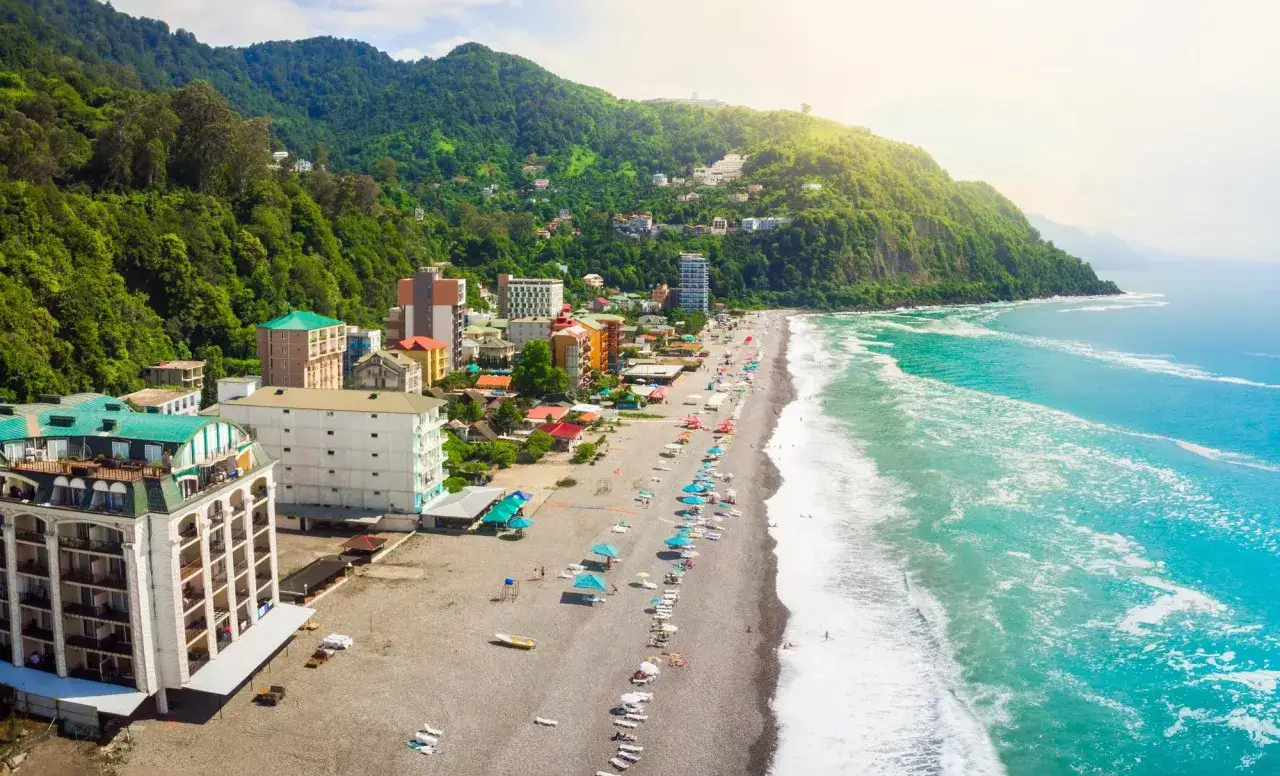 Widok z lotu ptaka na wybrzeże Gruzji. Plaże, hotele i zielone wzgórza nad turkusowym morzem.