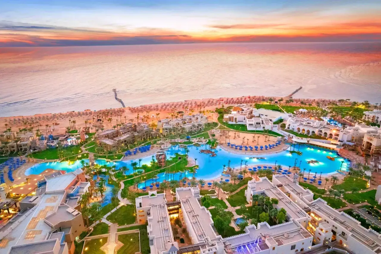Piękny widok na hotel Pickalbatros Oasis Port Ghalib o zachodzie słońca. Baseny, plaża i morze tworzą idealne miejsce na wakacje.
