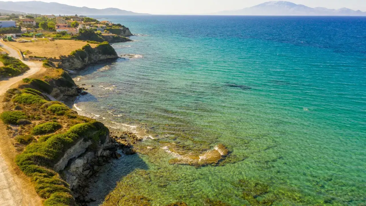 Malownicze wybrzeże Tragaki Zakynthos z klifami, zielenią i turkusowym morzem.