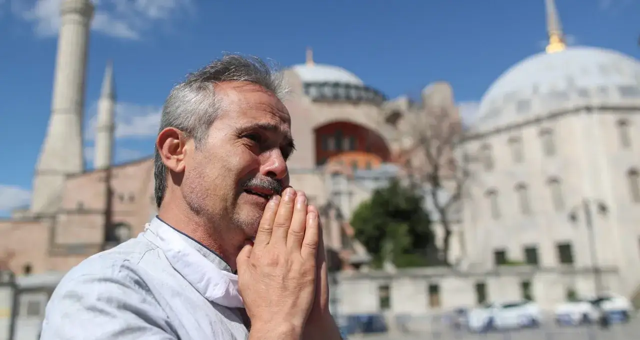 Mężczyzna modli się przed Hagia Sophia, symbolem bogatej historii i turcja religia.