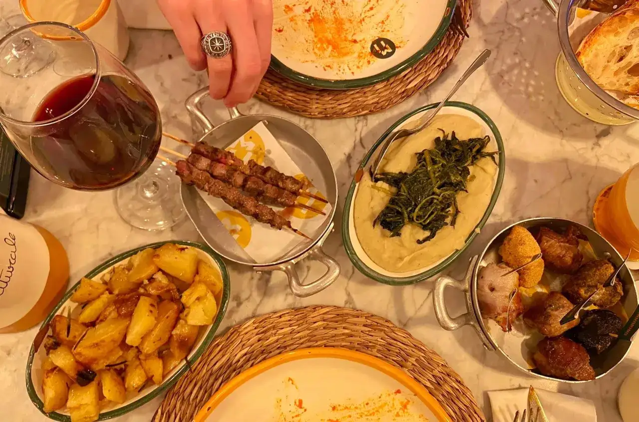 Pyszne jedzenie w Mediolanie: szaszłyki, pieczone ziemniaki, puree z zielonymi warzywami i pieczywo. Idealne miejsce, gdzie zjeść w Mediolanie.