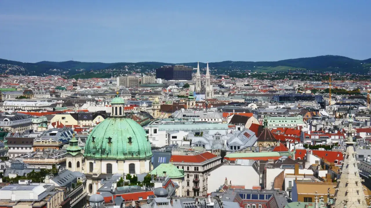 Panorama Wiednia z zieloną kopułą kościoła i wieżami. Idealne miejsce, by zobaczyć, co warto zwiedzić w tym mieście.