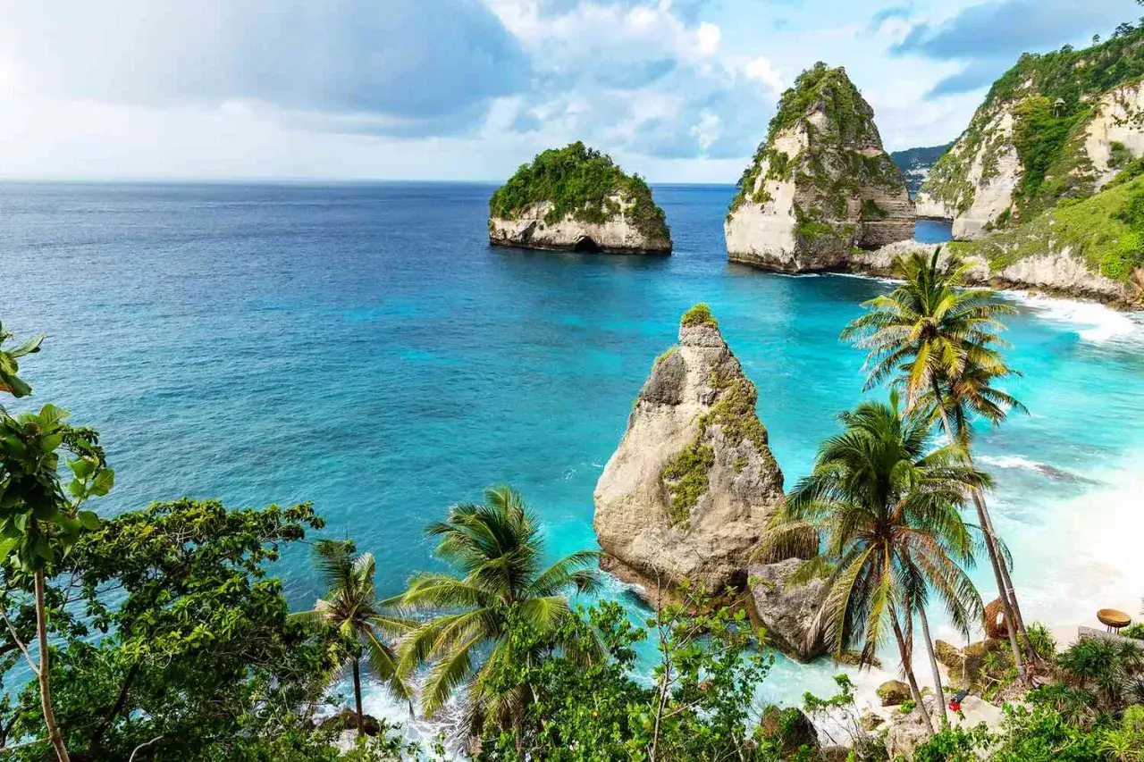 Rajska plaża z palmami i skalnymi formacjami, idealne miejsce na wakacje, kiedy na Bali.