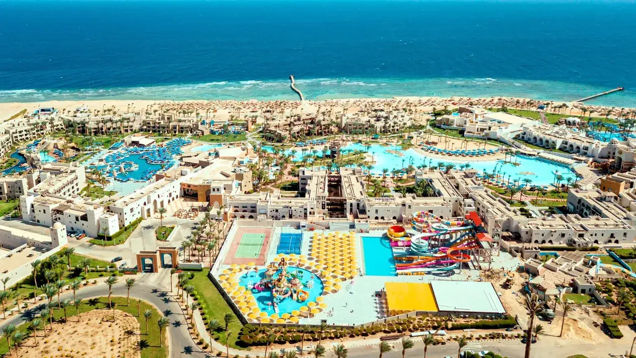 Widok z lotu ptaka na kompleks hotelowy Pickalbatros Oasis Port Ghalib z basenami, zjeżdżalniami i plażą.