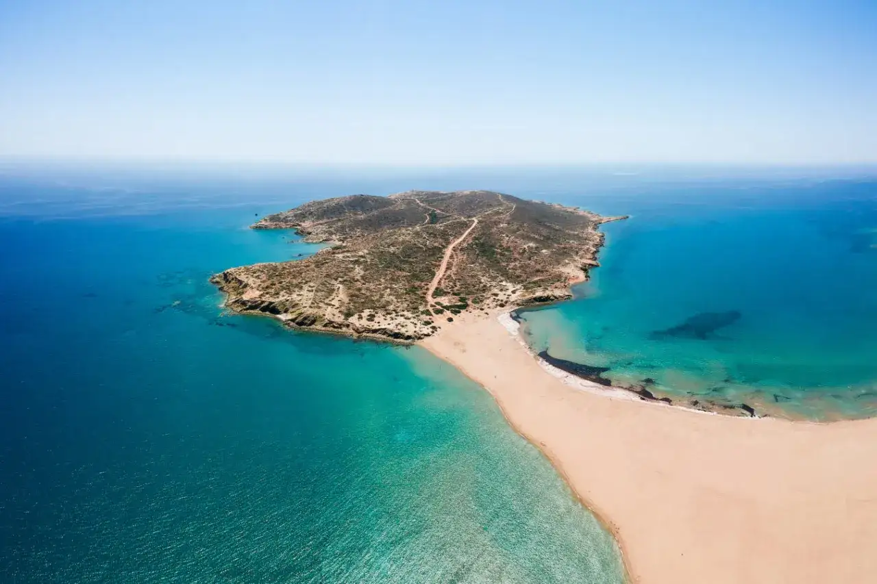 Przemierzając Rodos, odkrywasz najpiękniejsze miejsca: piaszczysta plaża łączy się z zieloną wyspą, otoczoną turkusowym morzem.