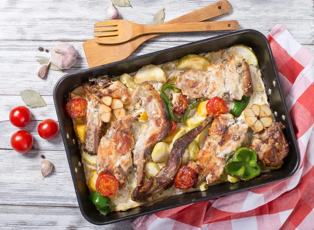 Pyszne pieczone mięso z warzywami, czosnkiem i pomidorkami. To tradycyjne maltańskie jedzenie, które zachwyca smakiem.