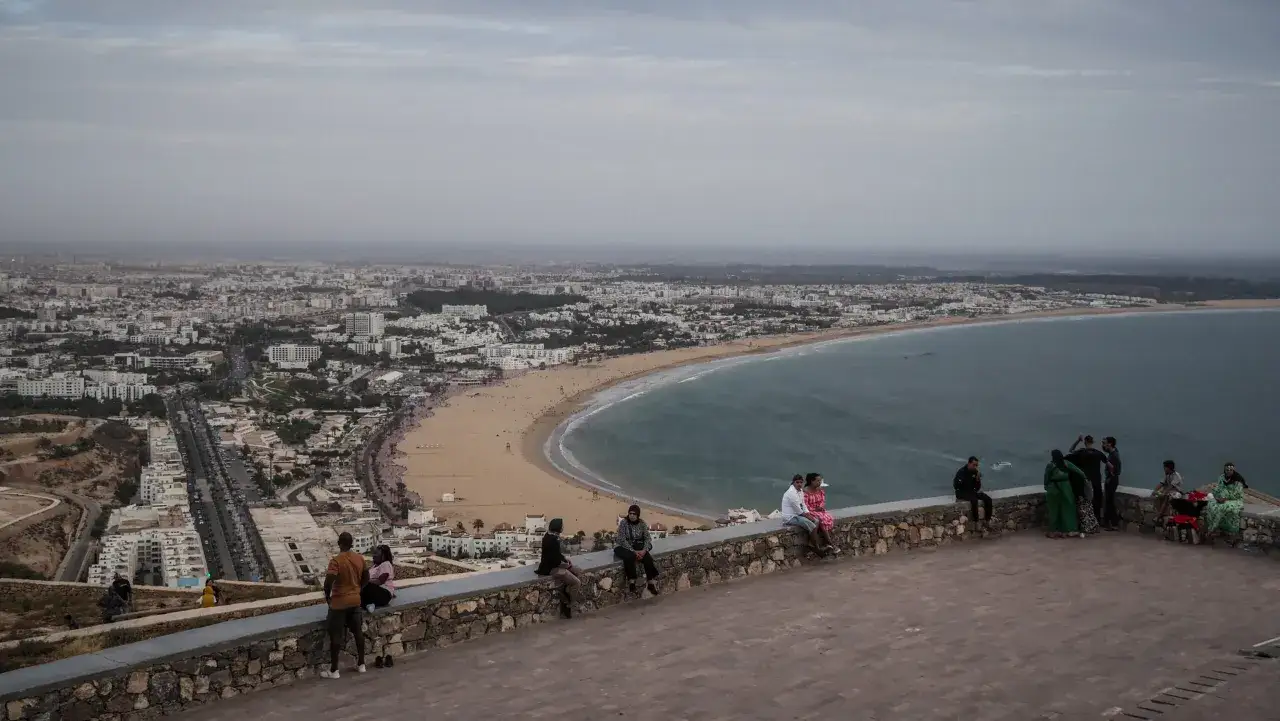 Agadir, marzec. Widok na miasto i plażę z tarasu widokowego, gdzie odpoczywają turyści. Pogoda pochmurna.