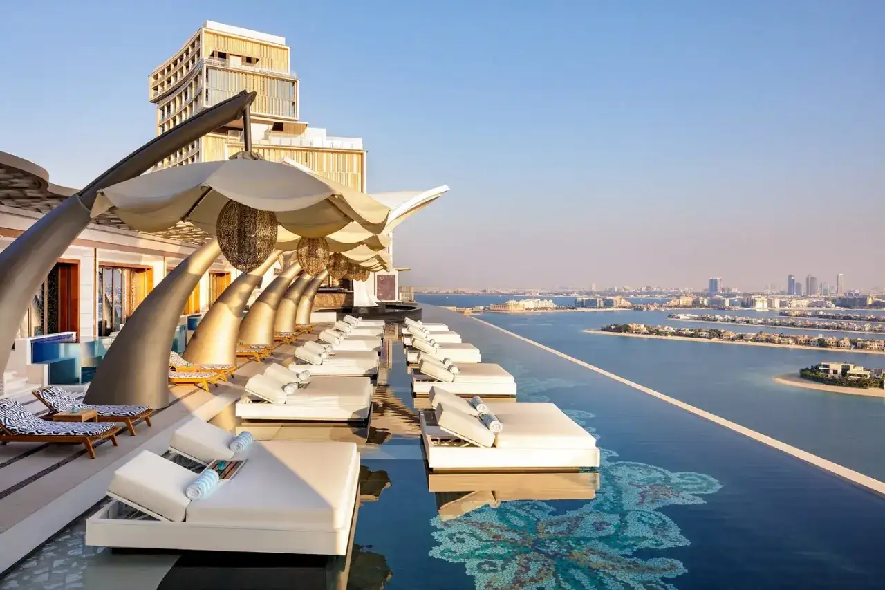 Luksusowy basen infinity z leżakami i widokiem na Dubaj. Idealne miejsce na relaks, zgodnie z top touristik opinie.