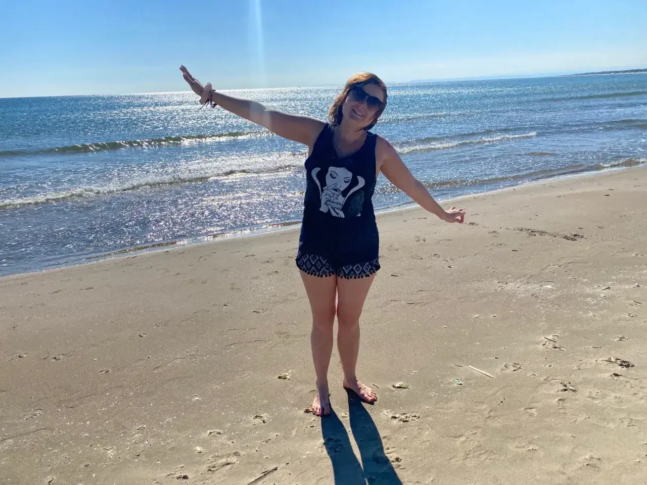 Sycylia w październiku: słoneczna plaża, błękitne morze i uśmiechnięta kobieta ciesząca się piękną pogodą.