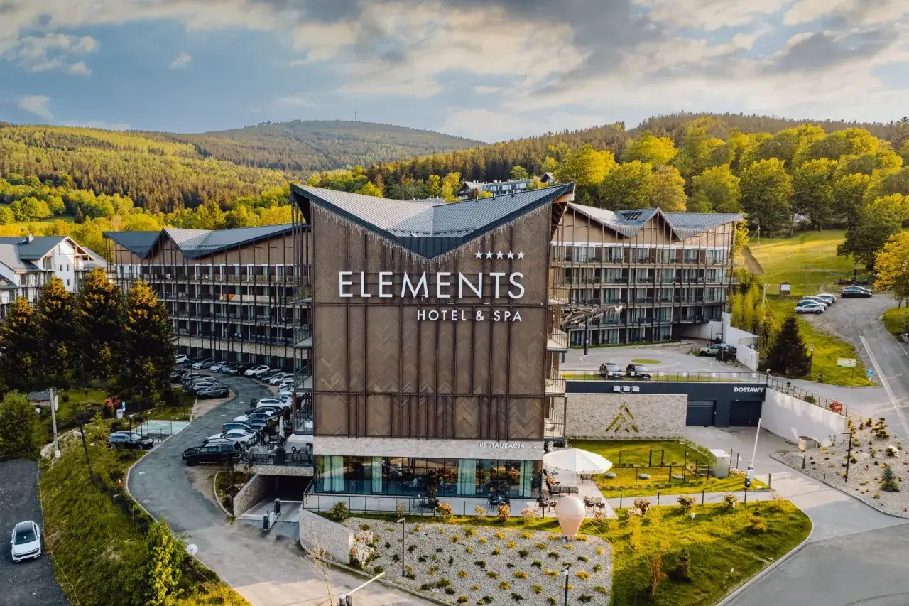 Nowoczesny hotel Elements w górach, idealny na rodzinne wakacje. Otoczony zielenią, z widokiem na las.