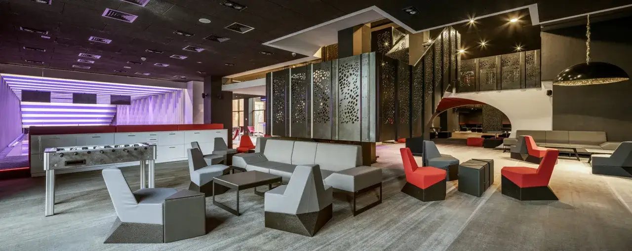 Nowy hotel dla teściów 2: nowoczesny lounge z piłkarzykami i wygodnymi fotelami.