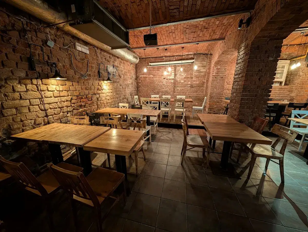 Wnętrze restauracji z ceglanymi ścianami i drewnianymi stołami. Idealne miejsce na pyszny ramen, jak sugerują ato ramen wro opinie.