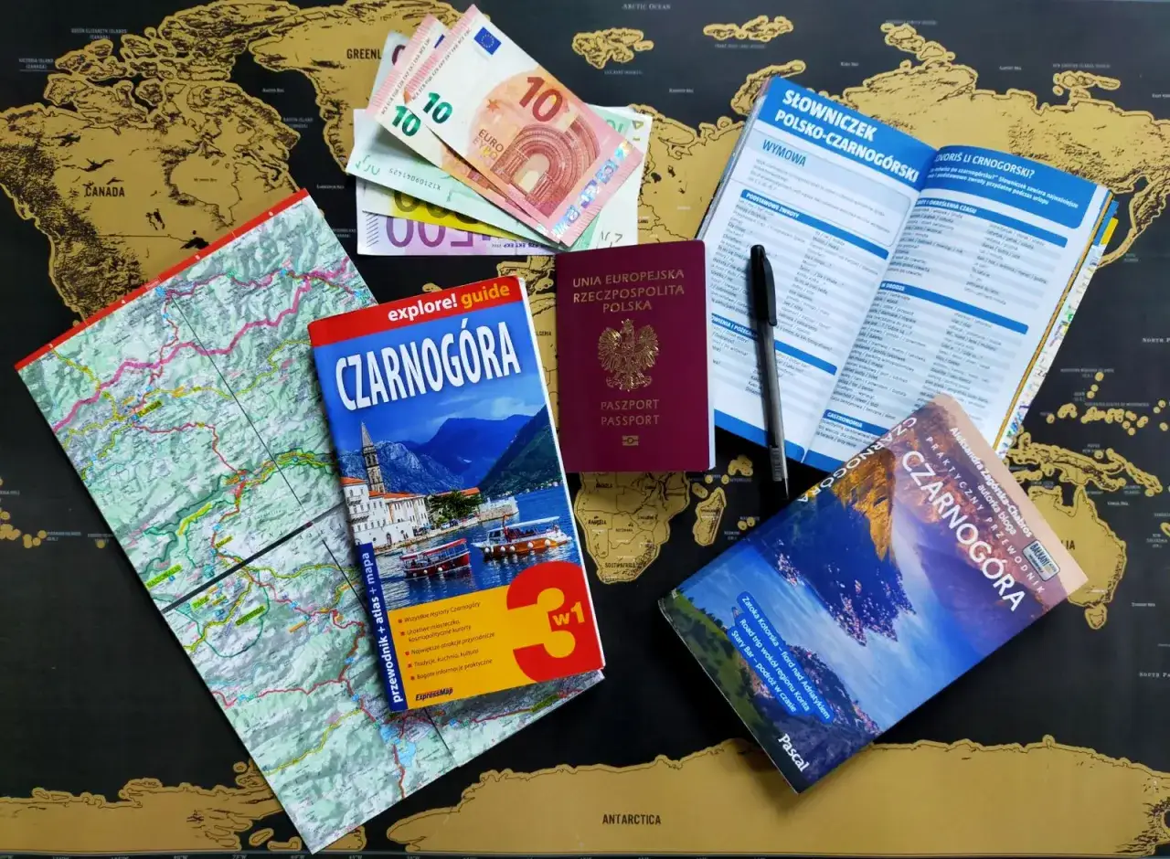 Paszport, pieniądze i przewodniki po Czarnogórze leżą na mapie świata. Czy do Czarnogóry potrzebny jest paszport? Tak, ten polski paszport jest gotowy do podróży.