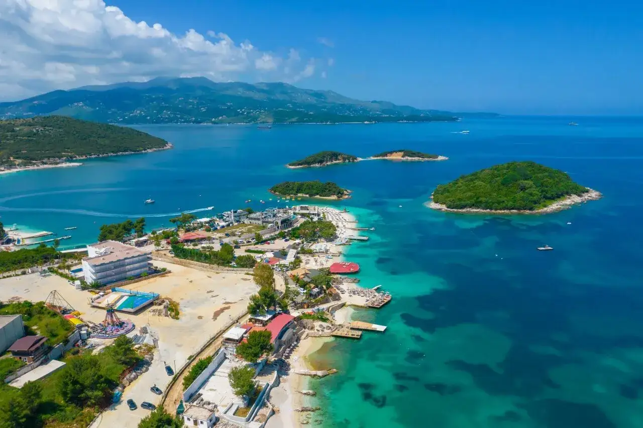Albania, czego nie wolno? Tu można wszystko! Widok na turkusowe morze, wyspy i kurort z plażami.