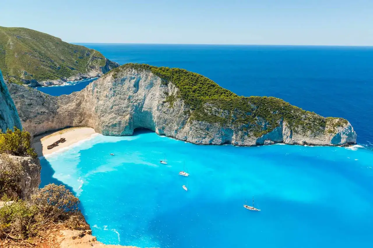 Słynna plaża Navagio w Grecji, z wrakiem statku na piasku i turkusowym morzem.